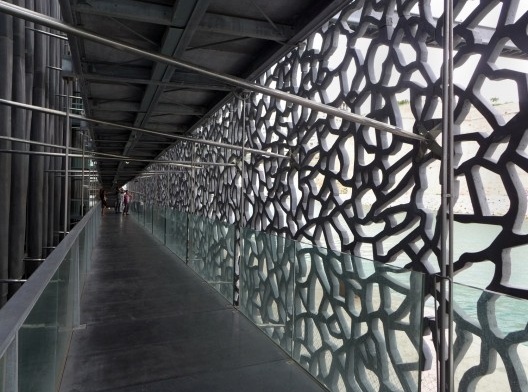 Museu das Civilizações da Europa e do Mediterrâneo – MuCEM, Marselha, 2013. concreto rendilhado que envolve parte do edifício, visto do interior da galeria que circunda o museu