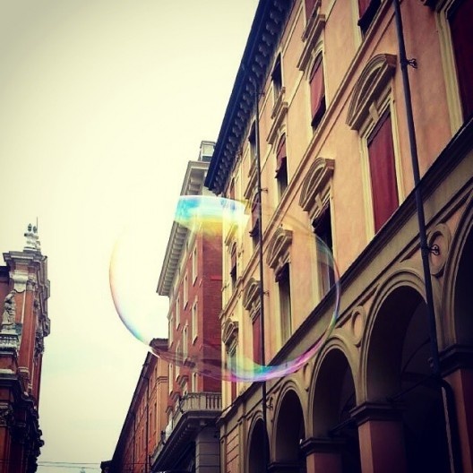 Uma das atividades comuns realizadas nos finais de semana: balões de sabão logo abaixo das construções porticadas da Via Indipendenza, Bolonha, 2014