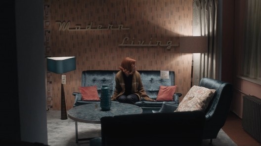 A protagonista, Elizabeth Harmon, compra mobiliário moderno. Na parede está escrito “modern living”, “viver moderno” em tradução livre. Cena do filme O Gambito da Rainha, direção de Scott Frank