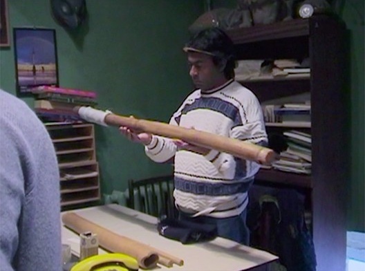 Airton Krenak manuseia instrumento de seu povo coletado pelo linguista russo Henrikh Maniser em 1912, hoje no acervo do Museu Kunstkamer, São Petersburgo, Rússia, fotograma do filme “Ailton Krenak, o sonho da pedra”