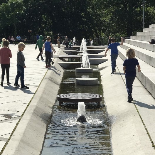 Israel Plads. Crianças escolares em seu horário de intervalo interagem no espaço público com demais pessoas. O respeito pela criança na Dinamarca fornece a elas uma impressionante liberdade dentro do espaço público