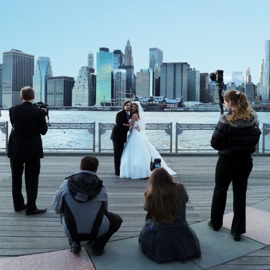 As fotos previsíveis podem ser flagradas na cena lugar-comum da Ponte Brooklyn de Nova York, com Manhattan ao fundo...