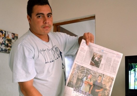 Djan Ivson Silva segura jornal em que ele e Rafael “Pixobomb” são destaques da reportagem sobre convite para a Bienal de Artes de Berlim em 2012