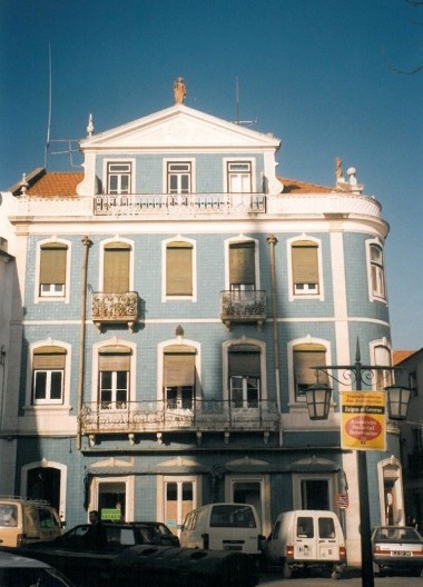 Fachada na Rua Visconde Serra do Pilar, esquina com a Rua Serpa Pinto, Santarém. Sob o frontão a imagem em terracota do Comércio