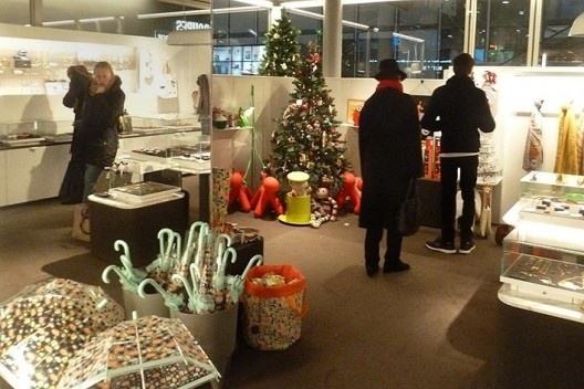 Indeciso entre guarda-chuvas, broches e pins, Poirot percebe um personagem de roupa e chapéu pretos, que lhe chama a atenção devido sua familiaridade.