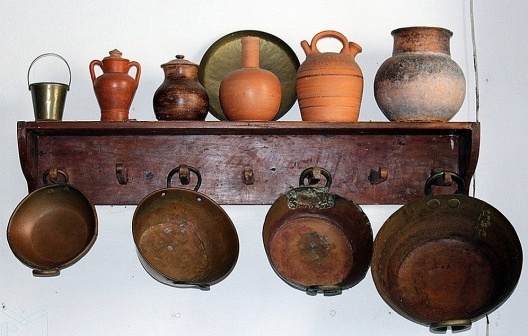 Tachos de cobre e ânforas de barro na cozinha da casa