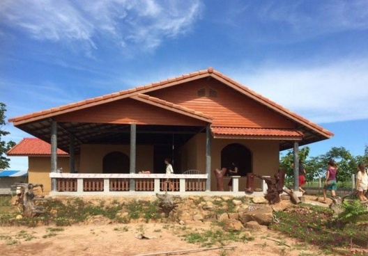 Fachada frontal da casa de adobe construída para família local do vilarejo, Tailândia, agosto, 2016