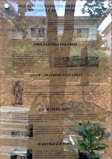 Painel colocado ao lado da placa com o nome da Escola, indicando e valorizando o novo uso no antigo imóvel