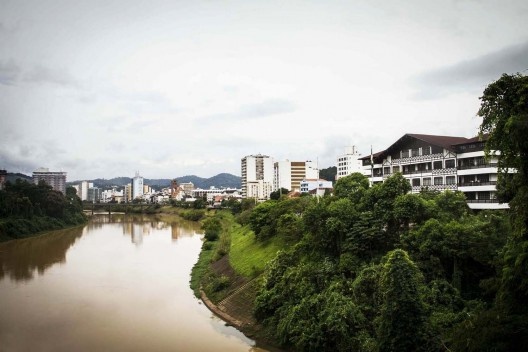 Blumenau. Vista do Rio Itajaí-Açu e da Avenida Beira-rio a partir da Ponte Aldo Pereira Andrade / Ponte de Ferro. Ao centro, a Catedral de São Paulo Apóstolo, junto a torre de sinos – arquiteto Gottfried Böhm; à extrema direita, a Prefeitura Municipal