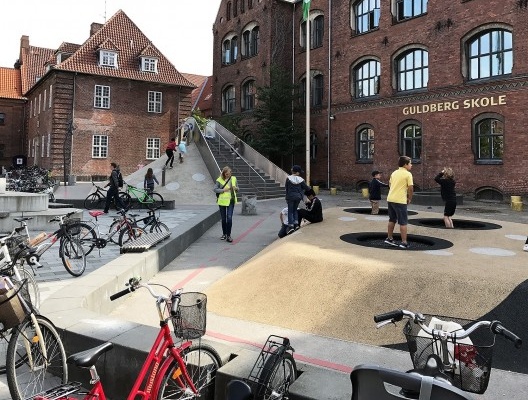 Praça pública utilizada pelos alunos da escola Guldberg. Notar o desenho especial dos elementos da praça como camas elásticas e escorregador gigante