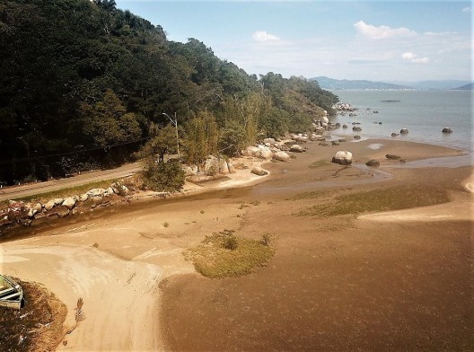 Aterro feito pelos sedimentos argilosos do pequeno córrego, redistribuídos pelas águas do mar