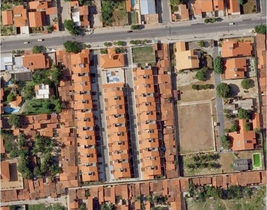 Foto aérea tendo o condomínio Jardins de Fátima 2, em destaque, cercado por favela.